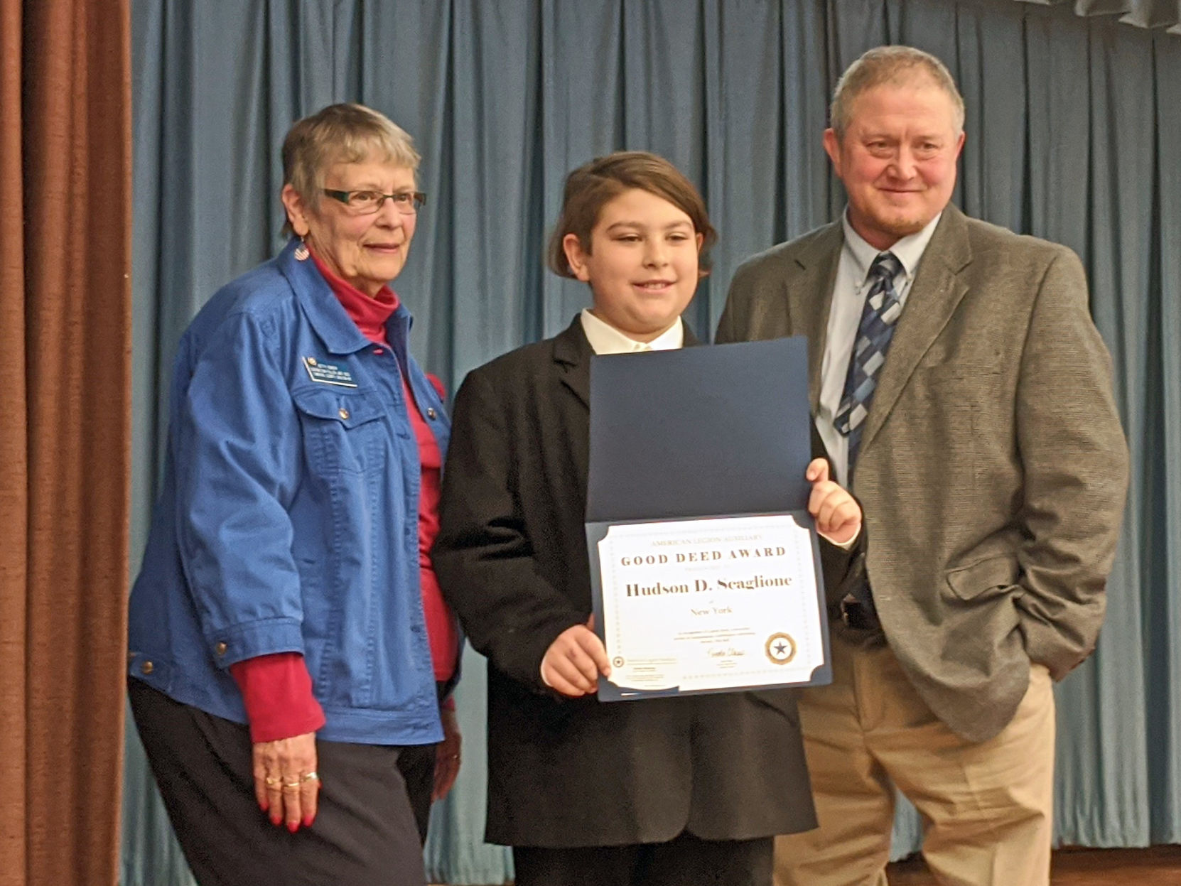Hudson Scaglione (center) holds his award with Betty Conger (left) and Principal Kent Maslin (right) standing by his sides.